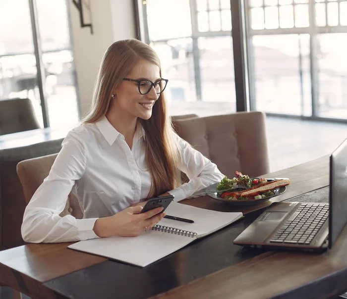 Empreendedora sorrindo ao usar o celular