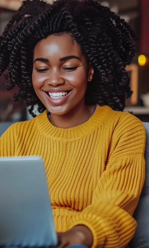 Mulher sorrindo usando o notebook em casa