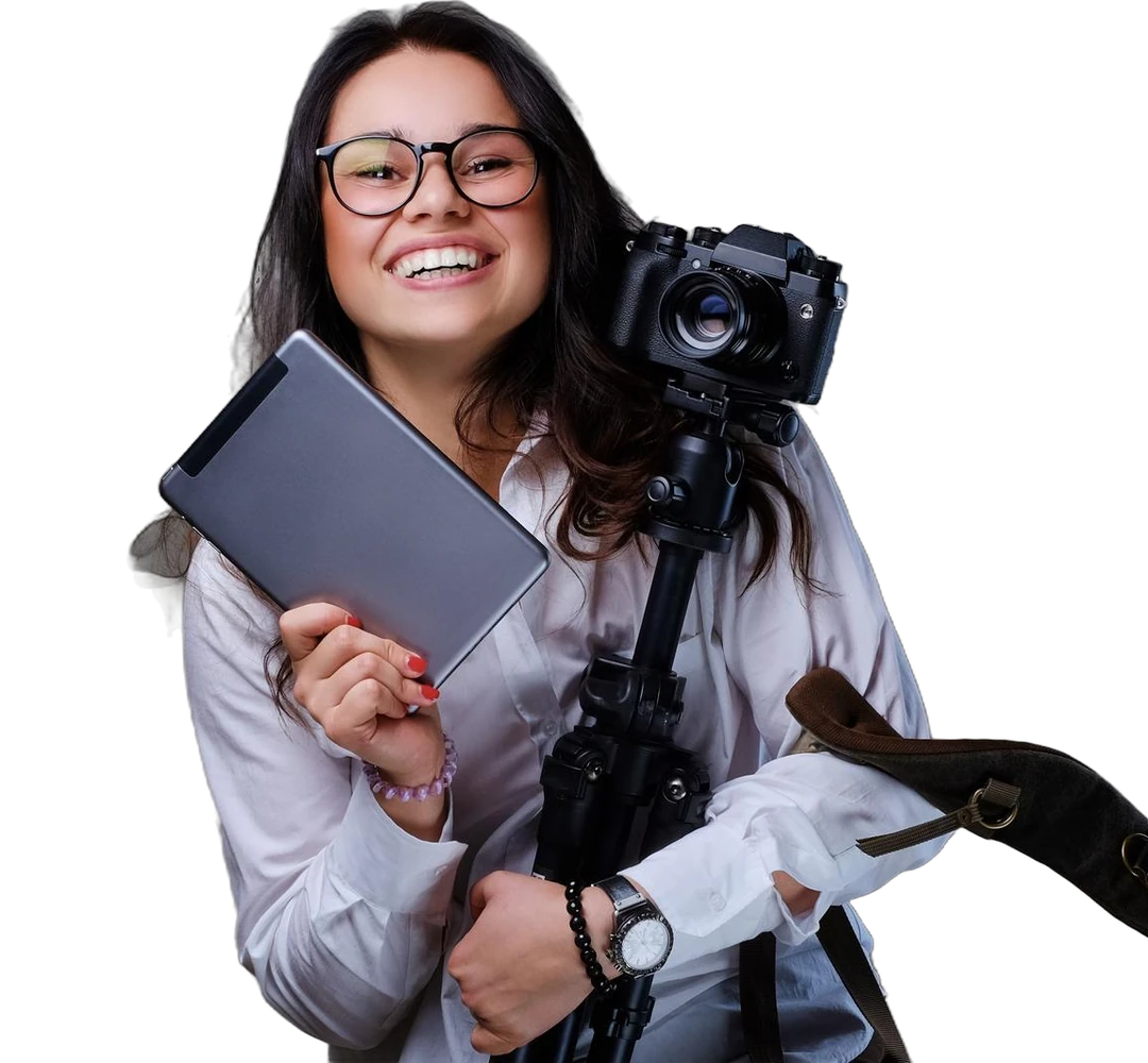 Fotógrafa sorrindo, de óculos, segurando um tablet e uma câmera no tripé