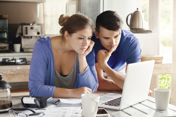 Casal de empreendedores Pesquisando sobre tipos de notas fiscais eletrônicas.