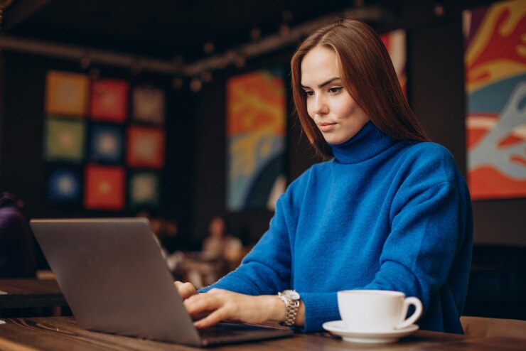 Empresária lendo no notebook sobre Tipos de notas fiscais para MEI.