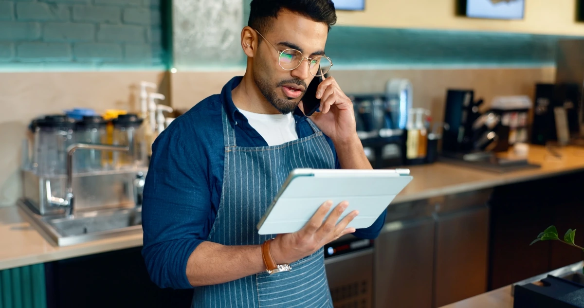 Empreendedor ao telefone conversando com possível atendente do suporte ClickNotas sobre notas fiscais MEI: quais os tipos e como emitir.