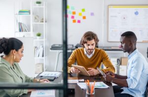 Empreendedores discutindo e fazendo anotações sobre o CEST (Código Especificador da Substituição Tributária).
