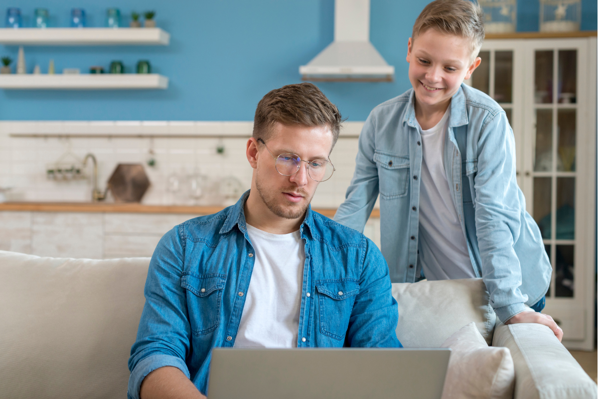 Empreendedor e seu filho lendo no notebook sobre: Chave de acesso da nota fiscal: o que é e onde encontrar.