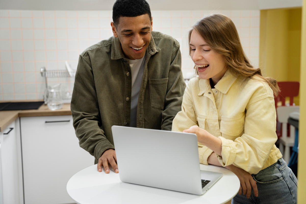 Casal de empresários lendo artigo no notebook sobre: Certificado digital para empresas: quando é obrigatório e como escolher o tipo ideal.