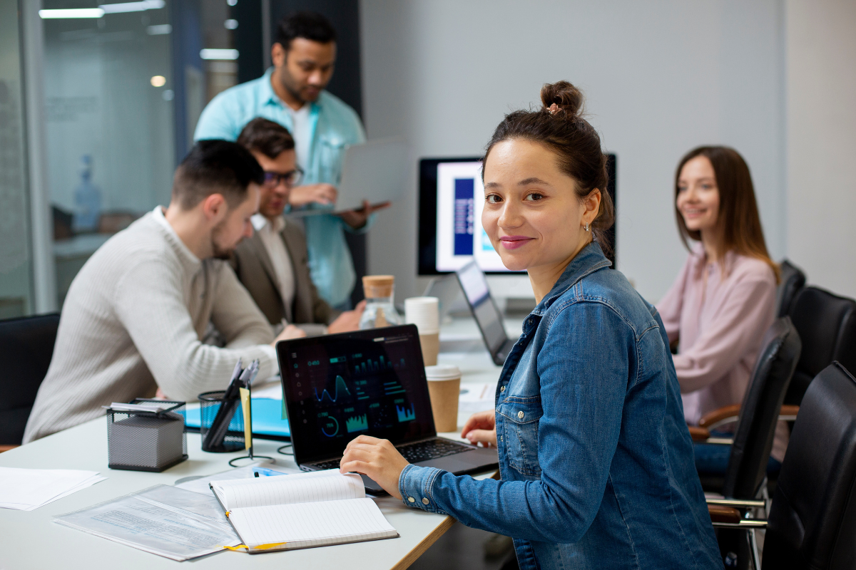 Equipe de contadores Conversando e lendo em seus computadores sobre Quais impostos incidem sobre uma nota fiscal: ICMS, ISS, PIS e COFINS explicados.