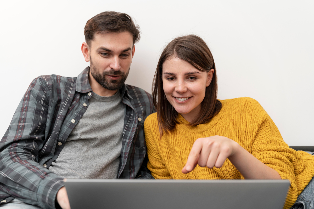 Casal de contadores lendo em um notebook e conversando sobre: PIS e COFINS: eles são importantes para quem emite nota fiscal?