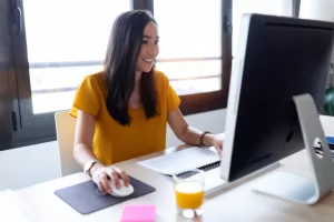 Contadora lendo artigo em seu computador sobre: O que é código de situação tributária (CST) e como preencher corretamente.