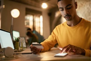 Empresário lendo em seu celular sobre Nota fiscal para prestação de serviço técnico fora do domicílio: como preencher.