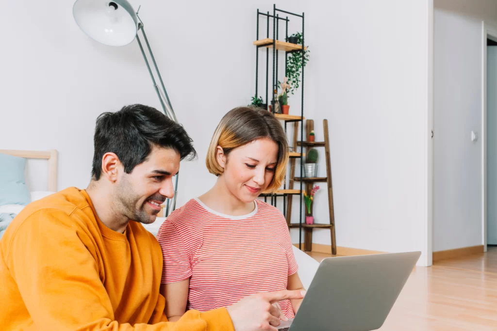 Casal de contadores lendo artigo no notebook sobre: ISSQN: tudo que você precisa saber.