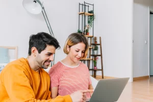 Casal de contadores lendo artigo no notebook sobre: ISSQN: tudo que você precisa saber.