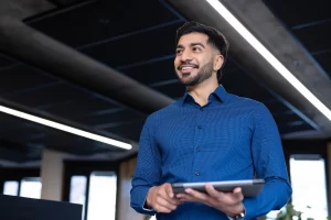Empresário com tablet em mãos após emitir nota fiscal de prestação de serviço com venda de produto.