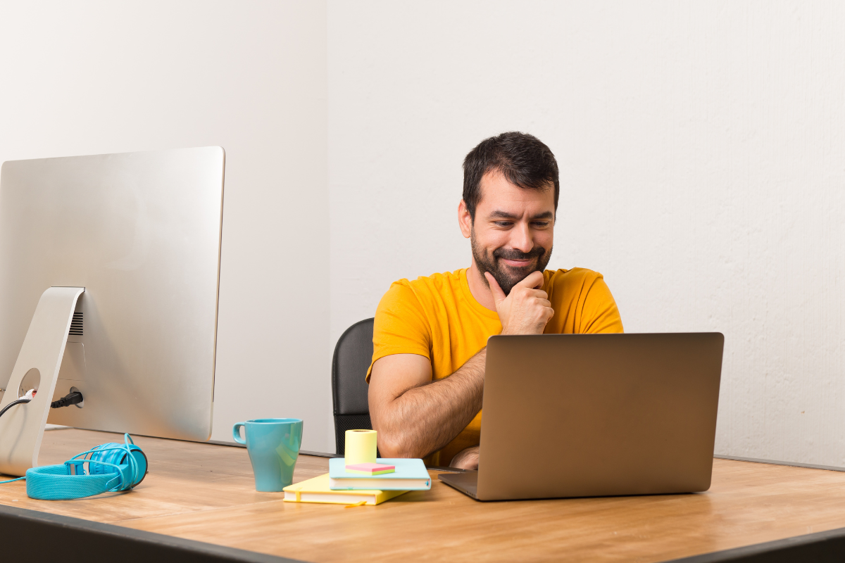 Empreendedor lendo artigo no seu notebook: Como emitir nota fiscal para reembolso de despesas: quais regras sua empresa precisa seguir.