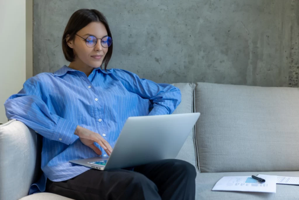 Empresária sentada em frente ao seu notebook lendo artigo sobre: Como funciona a nota fiscal de entrada: quando usar e como registrar corretamente.
