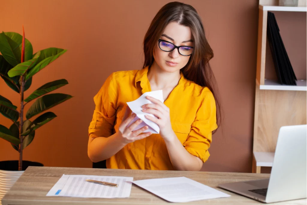 Empresária com notas fiscais na mesa após emissão de nota fiscal com antecipação de ICMS.