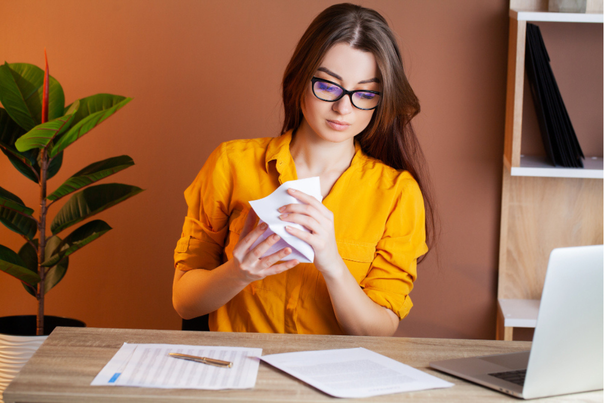 Empresária com notas fiscais na mesa após emissão de nota fiscal com antecipação de ICMS.