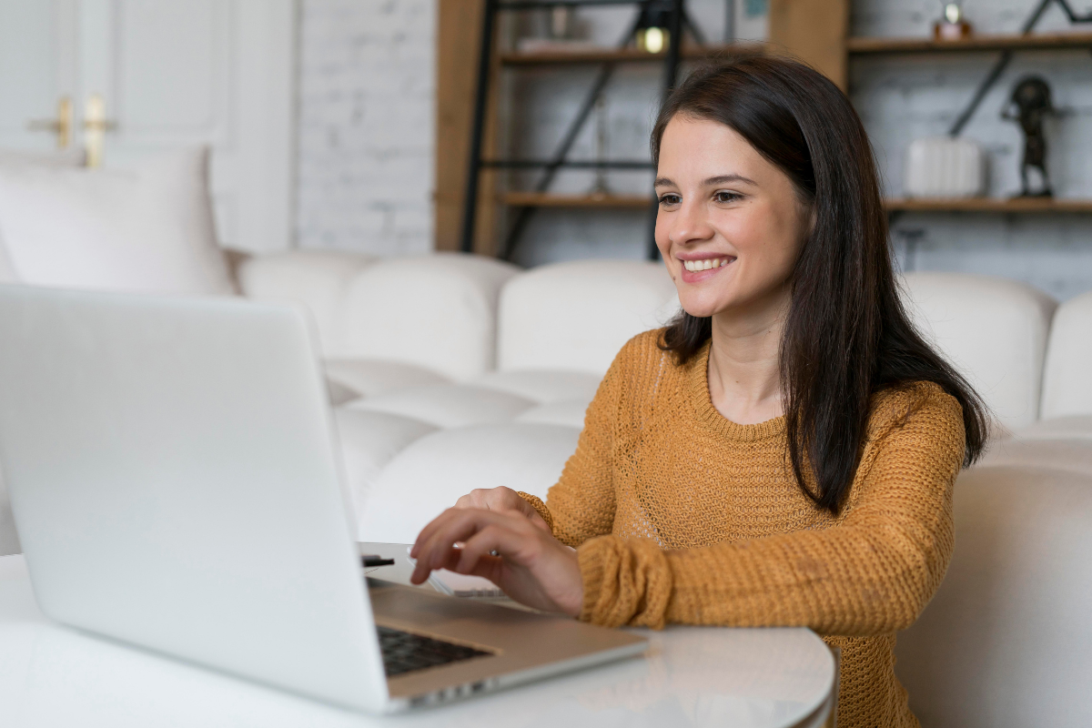 Mulher empresária, sentada usando um notebook sobre uma mesa em ambiente de escritório representando: CFOP 2102: tudo sobre a compra para comercialização.