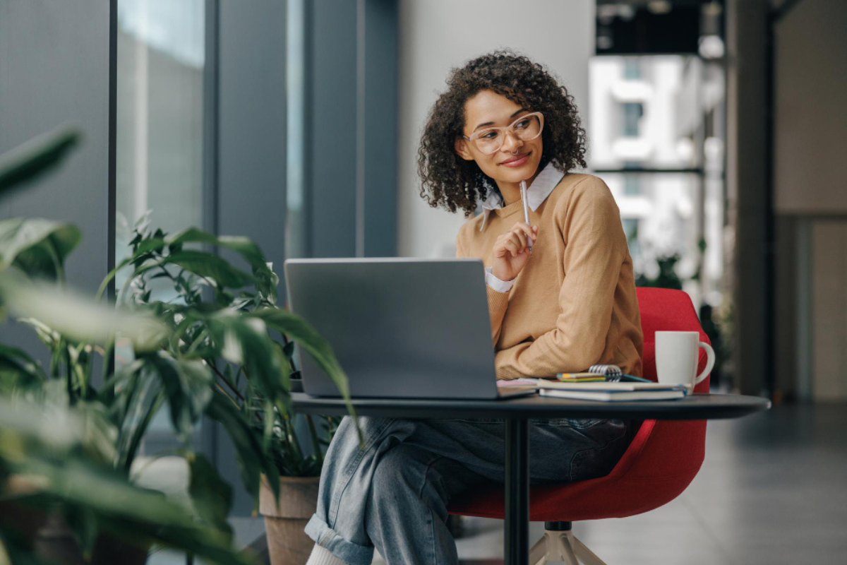 Mulher em ambiente de escritório sofisticado sentada usando um notebook sobre uma mesa representando: Quando o ICMS será extinto?