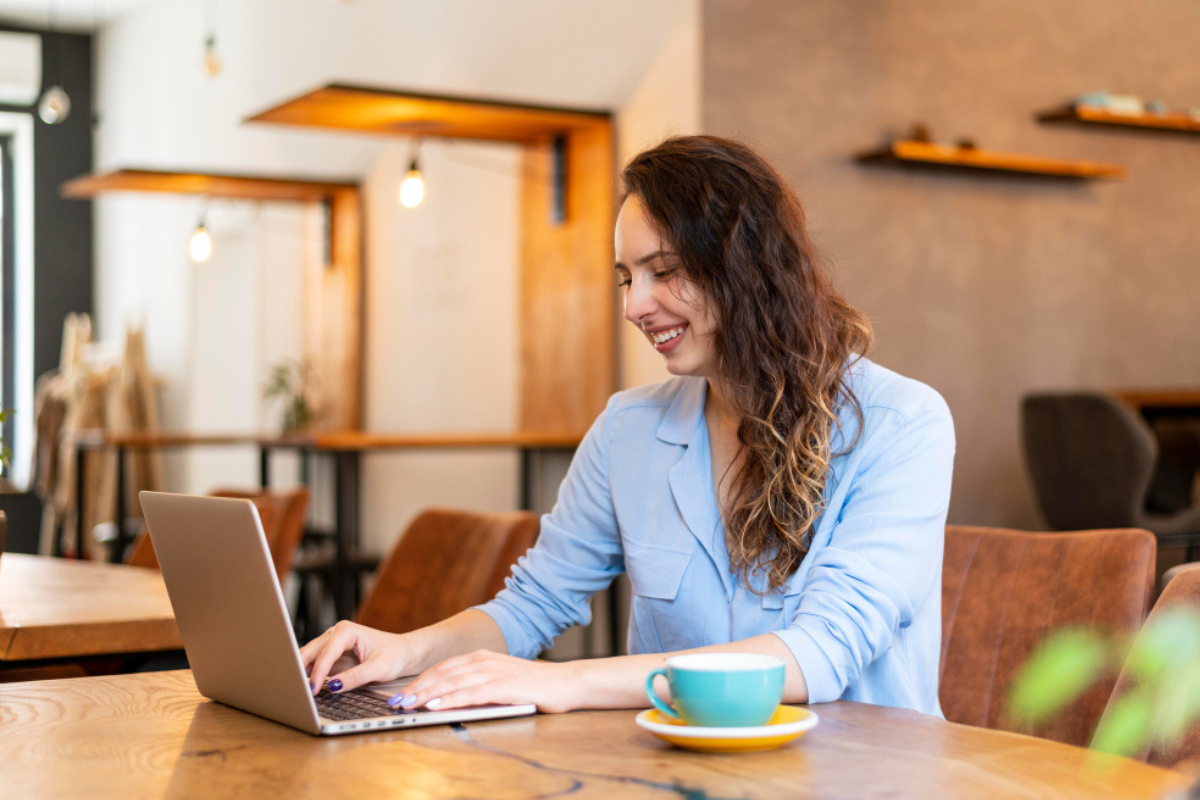 Mulher sentada usando notebook sobre uma mesa em ambiente de home office representando: O que são obrigações fiscais?