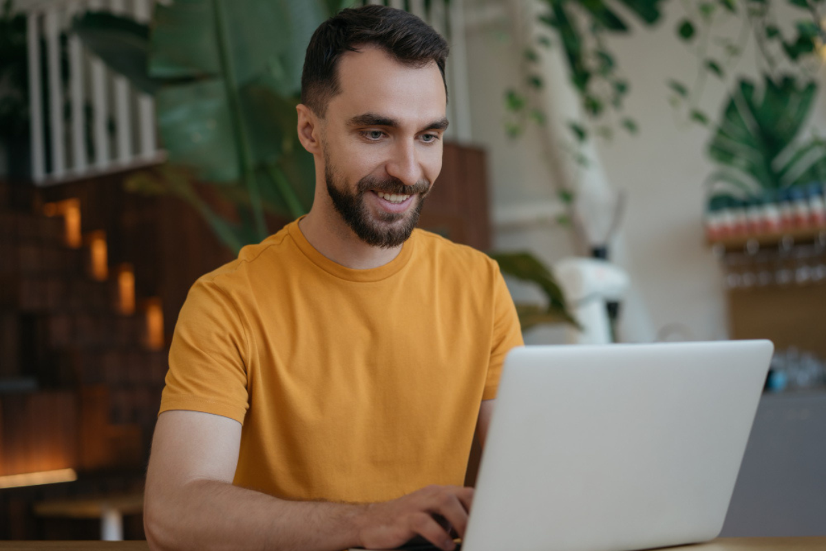 Homem sentado trabalhando em um notebook em ambiente de escritório representando: O que é o efeito cascata na tributação?