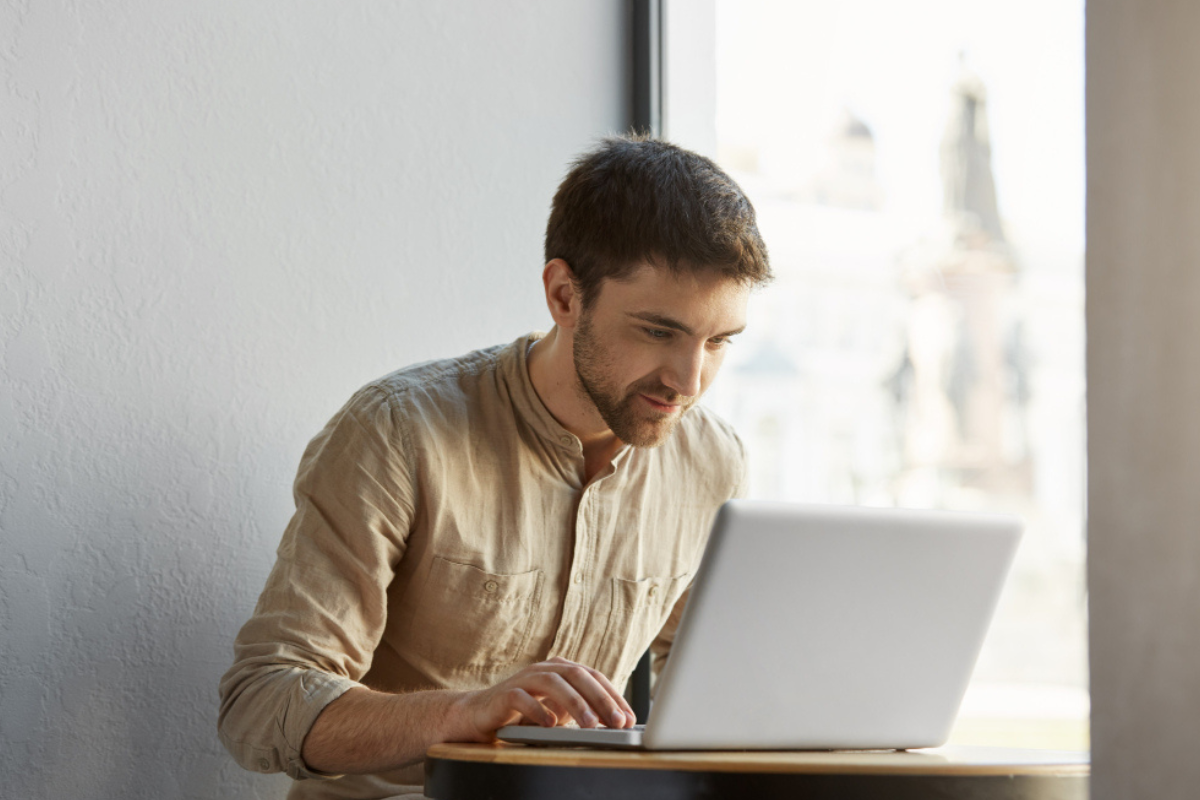 Homem sentado trabalhando em um notebook em ambiente de escritório representando: Gestão eletrônica de documentos fiscais: o que a legislação exige.
