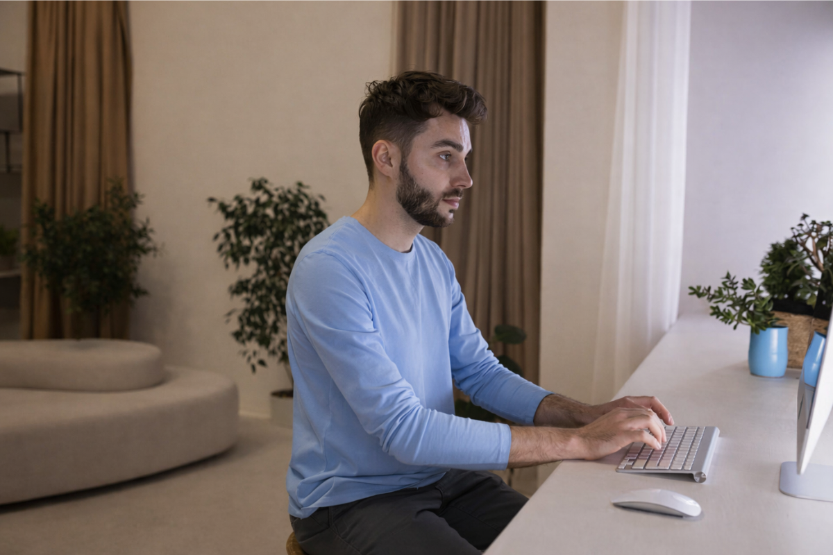 Homem sentado trabalhando em um computador em ambiente de home office representando: NFS-e nacional 2026: o guia completo.