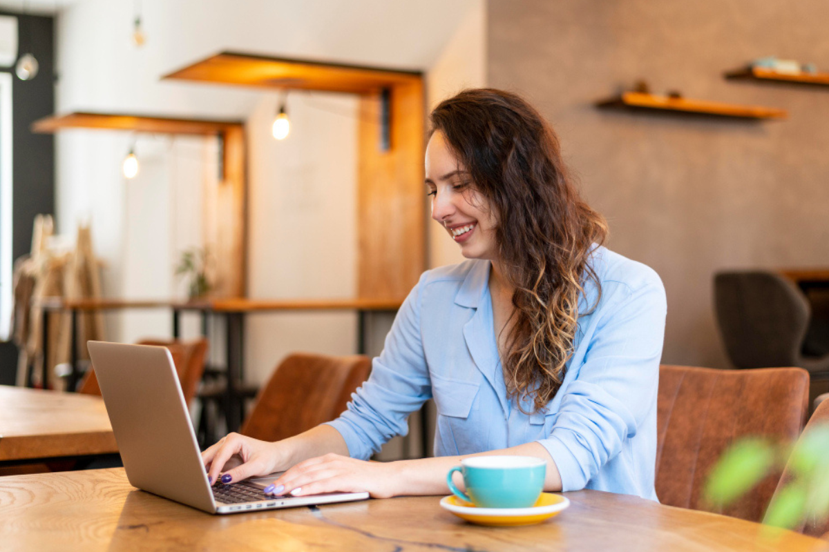 Mulher trabalhando em um notebook sobre uma mesa em ambiente de escritório representando: Repartição tributária: o que é e como funciona no Brasil?