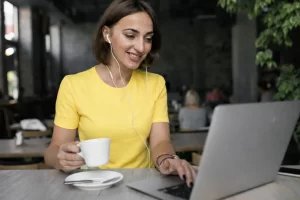 Mulher trabalhando em um notebook sobre uma mesa em ambiente de escritório representando: Reforma Tributária: vale a pena trocar o regime da empresa?