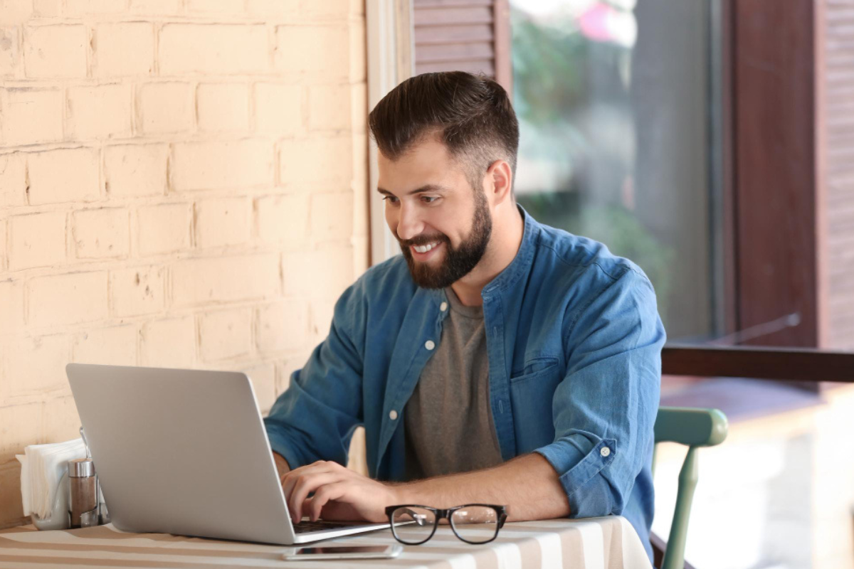 Homem sentado trabalhando em um notebook em ambiente home office representando: Imposto Seletivo: qual o papel do contador no novo tributo?