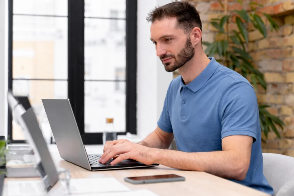 Homem sentado trabalhando em um notebook em ambiente home office representando: SPED Fiscal: quais são os tipos e o que muda na Reforma Tributária?