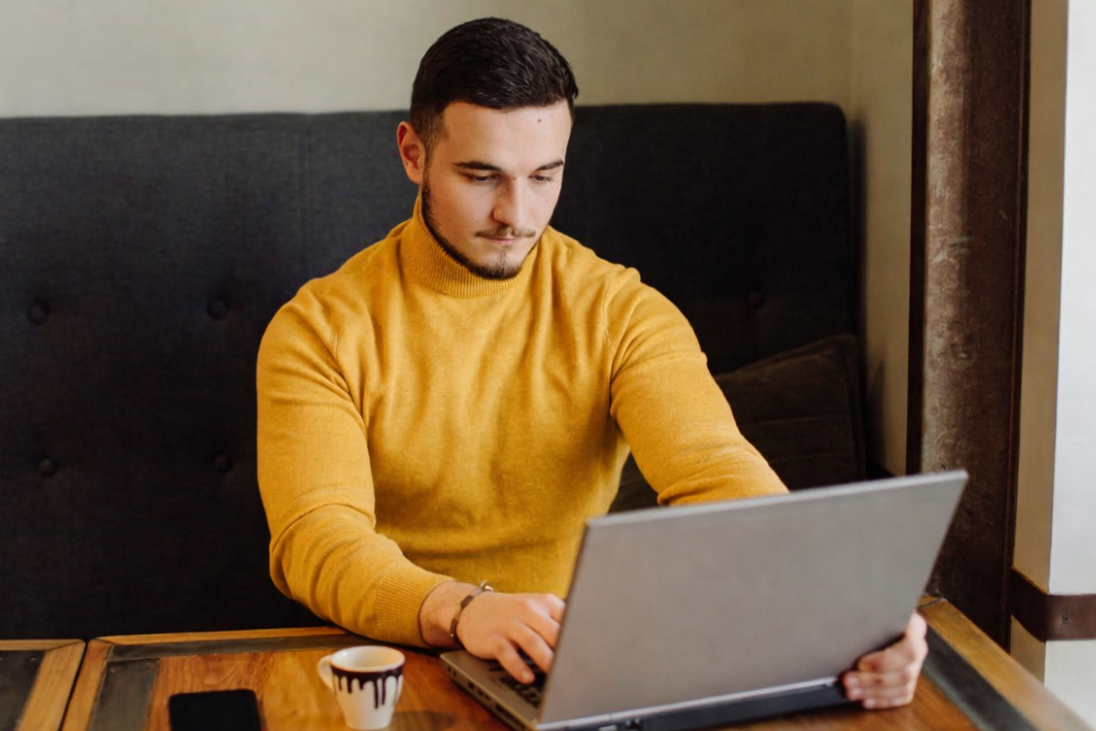 Homem sentado trabalhando em um notebook em ambiente home office representando: Transição da Reforma Tributária: checklist contábil, fiscal e financeiro para 2026.