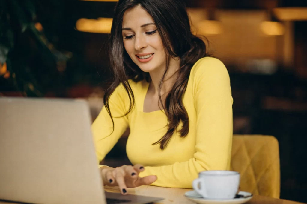 Mulher trabalhando em um notebook sobre uma mesa em ambiente de escritório representando: Segurança jurídica para micro e pequenas empresas na Reforma Tributária: mito ou realidade?