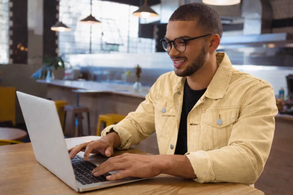 Homem sentado trabalhando em um notebook em ambiente home office representando: Parametrização fiscal errada: quais são os riscos financeiros e operacionais na Reforma Tributária.
