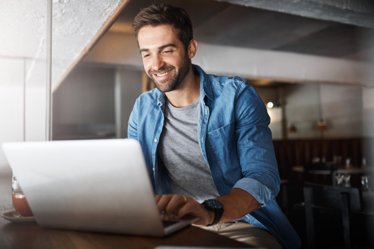 Homem sentado trabalhando em um notebook em ambiente home office representando: CFOP 1551: compra de bem para o ativo imobilizado.