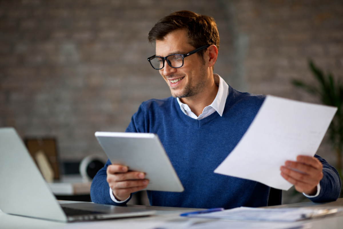Homem sentado trabalhando em um notebook em ambiente home office representando: CFOP 2403: compra para comercialização em operação com mercadoria sujeita ao regime de substituição tributária.