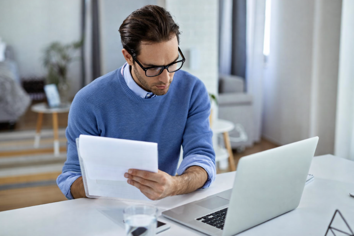 Homem sentado trabalhando em um notebook em ambiente home office representando: Como evitar inconsistências entre notas fiscais e apuração de impostos?