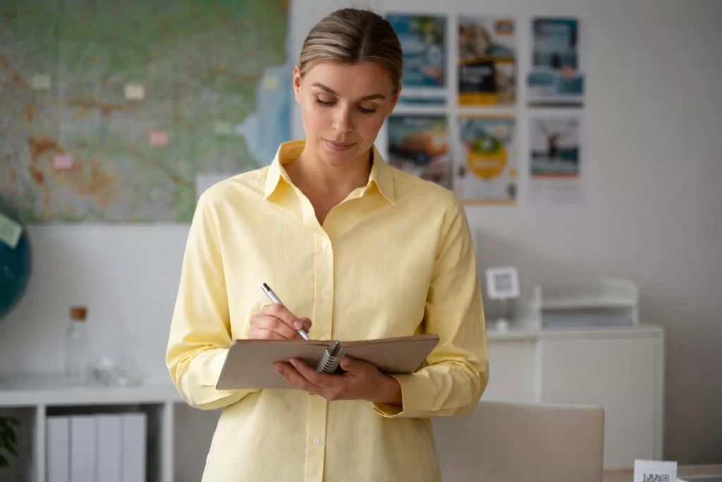 Mulher empresária andando com prancheta em mãos fazendo anotações em ambiente de escritório representando: Governança empresarial para microempresas: por onde começar?