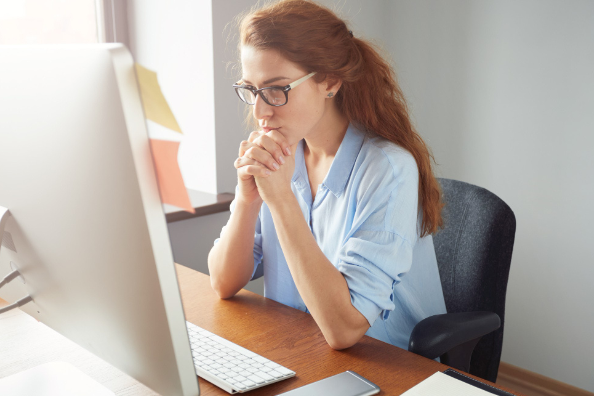 Mulher trabalhando em um computador em ambiente de escritório representando: CST e Reforma Tributária: o que vai mudar?