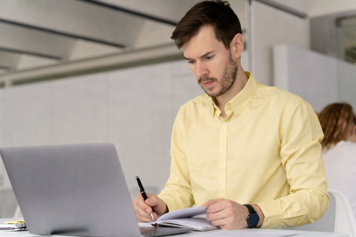 Homem sentado trabalhando em um notebook em ambiente home office representando: Códigos fiscais: como evitar erros na apuração de tributos na NF na Reforma Tributária.