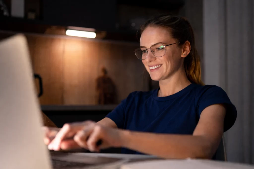 Mulher trabalhando em um notebook sobre uma mesa em ambiente de escritório representando: Defesa administrativa tributária: como funciona na prática?