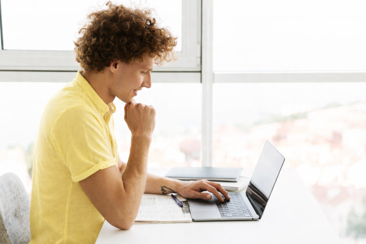 Homem sentado trabalhando em um notebook em ambiente home office representando: O que fazer ao receber uma notificação fiscal?