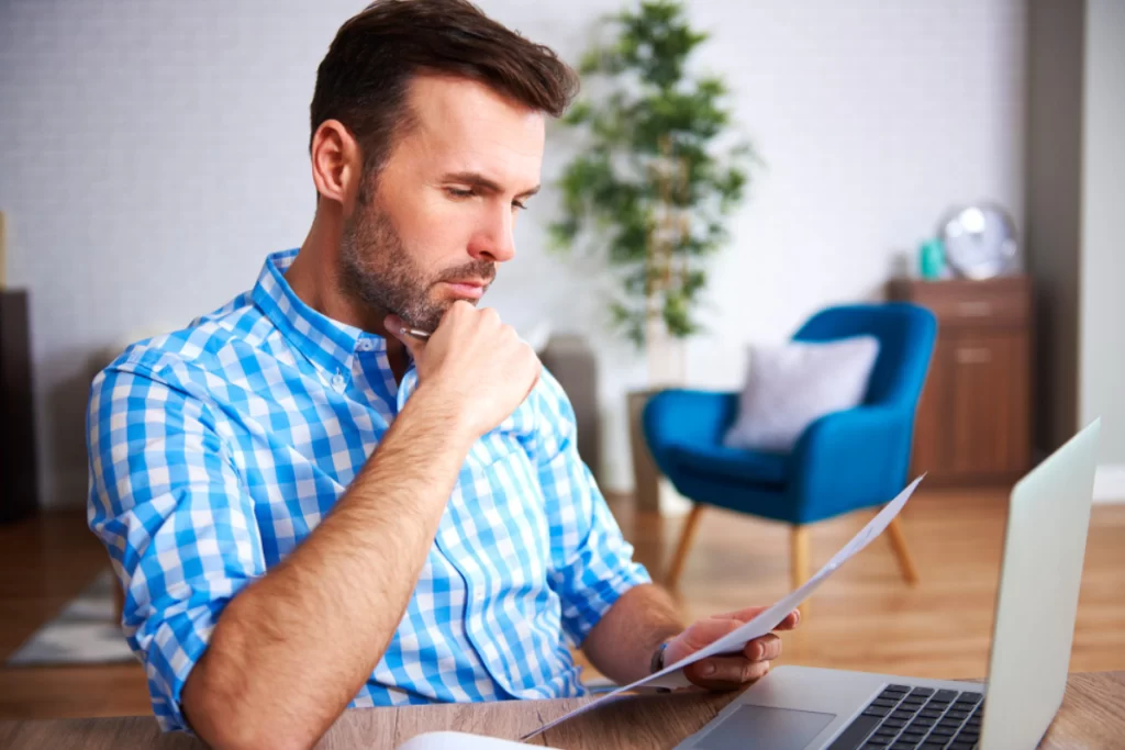 Homem sentado trabalhando em um notebook em ambiente home office representando: Execução fiscal: quando o problema vira judicial?