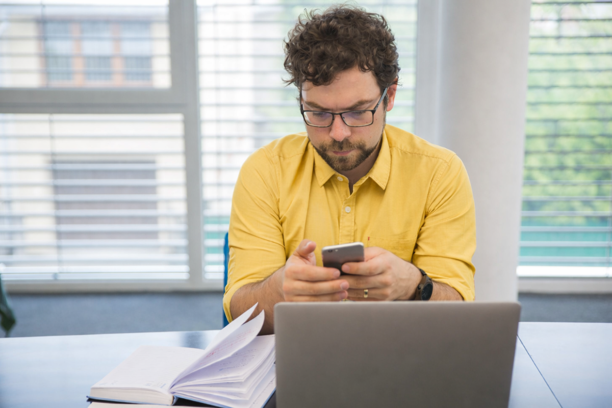 Homem sentado trabalhando em um notebook em ambiente home office representando: Conciliação entre XML e escrituração fiscal.