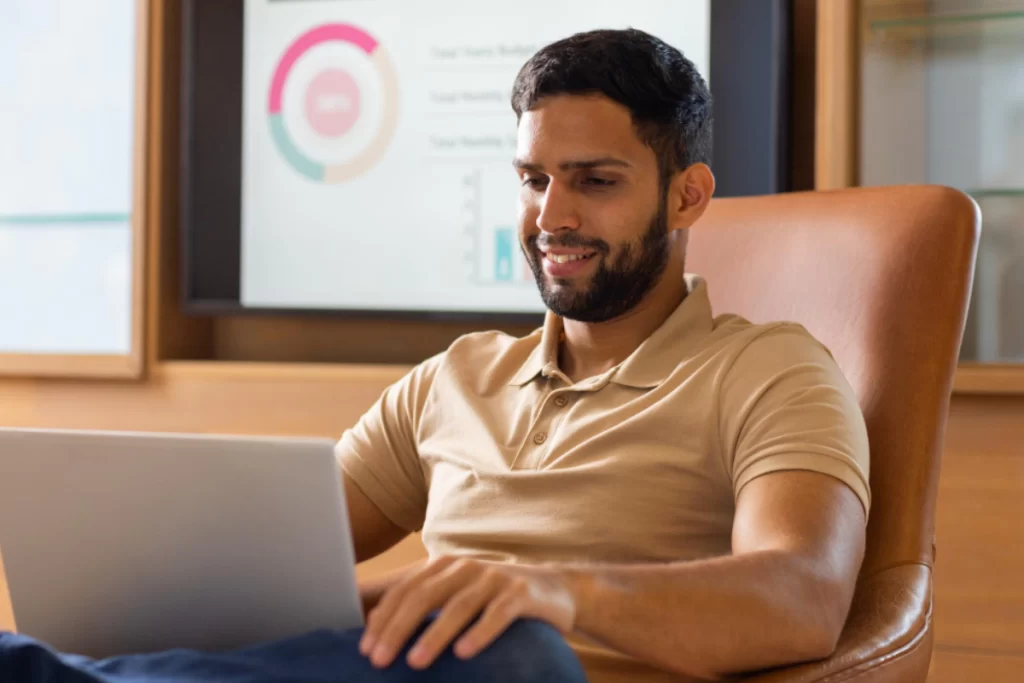 Homem sentado trabalhando em um notebook em ambiente home office representando: Riscos tributários invisíveis no crescimento da empresa.