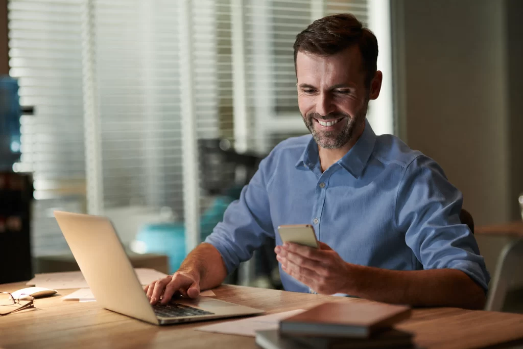 Homem sentado trabalhando em um notebook em ambiente home office representando: Qual a relação entre emissão de notas fiscais e controle de estoque?