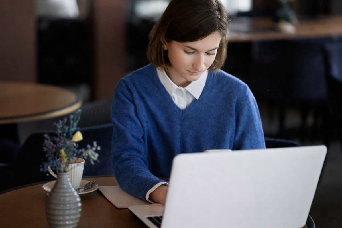 Mulher trabalhando em um notebook sobre uma mesa em ambiente de escritório representando: Precificação na Reforma Tributária: o que muda com o fim do ICMS e ISS.
