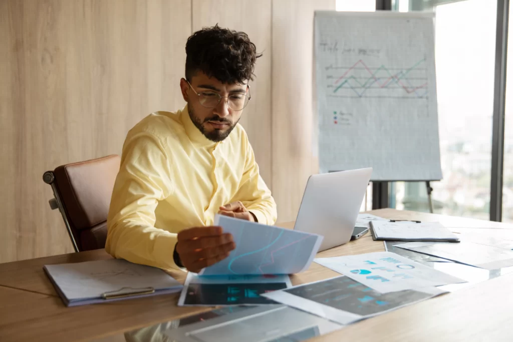 Homem sentado trabalhando em um notebook em ambiente home office representando: Como evitar divergência entre NF-e e SPED Fiscal.