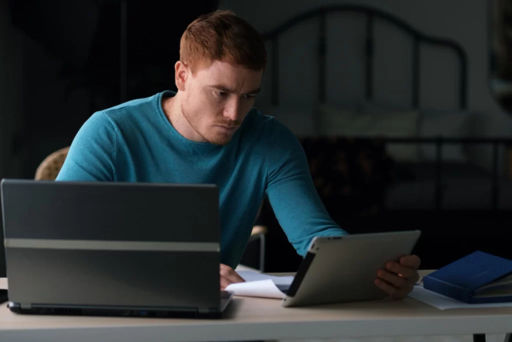Homem sentado trabalhando em um notebook sobre uma mesa em ambiente home office representando: Como um erro no XML pode impactar no faturamento?
