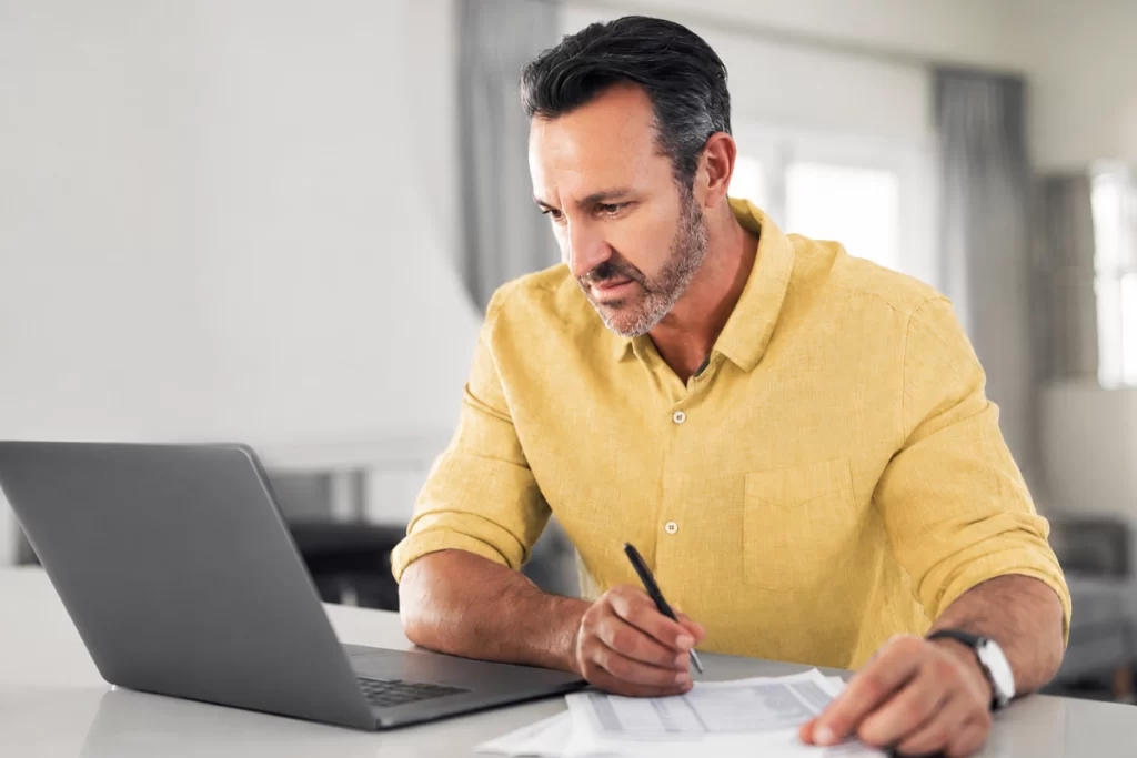 Homem em ambiente de escritório trabalhando em um notebook sobre uma mesa de escritório representando: O que caracteriza erro fiscal na emissão de nota?