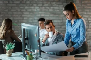 Equipe de profissionais trabalhando em conjunto em frente a um computador em ambiente de escritório sobre Como o split payment vai afetar o fluxo de caixa de quem vende pelo e-commerce.